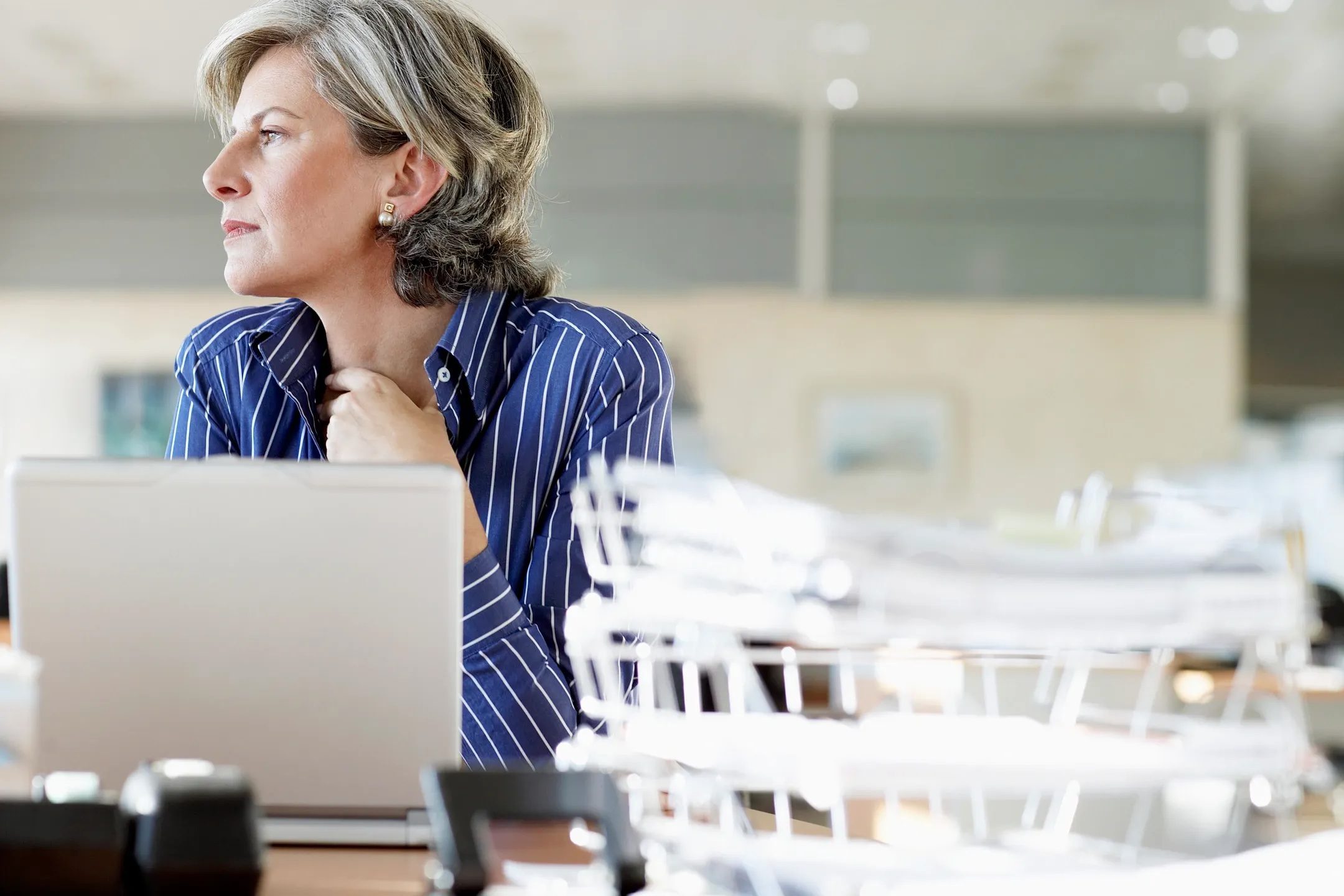 Woman reflecting at her desk while considering one on one executive coaching