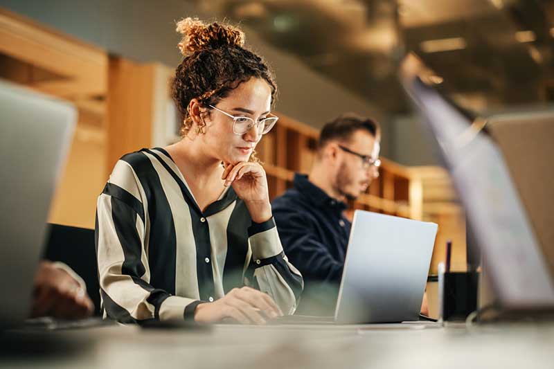 Focused woman working independently during an executive coaching program