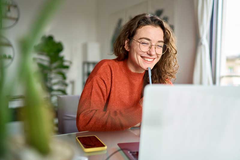 Professional woman smiling during virtual executive leadership coaching session.