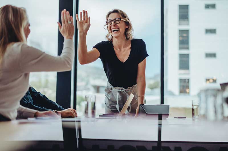 Two professional women sharing a moment of trust during confidential executive coaching.
