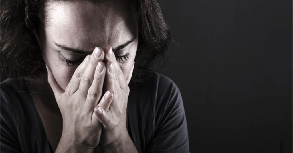 Strategies to Prevent Burnout – Recognising the Signs and Taking Action Woman holding her face in her hands showing signs of exhaustion, representing the importance of using strategies to prevent burnout.