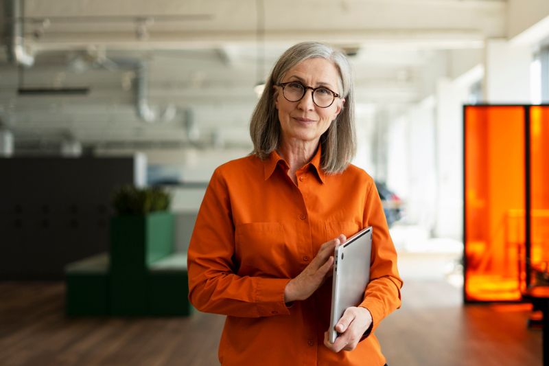 Executive Leadership Coaching for Women Executive woman smiling confidently in a modern office, representing executive leadership coaching for women