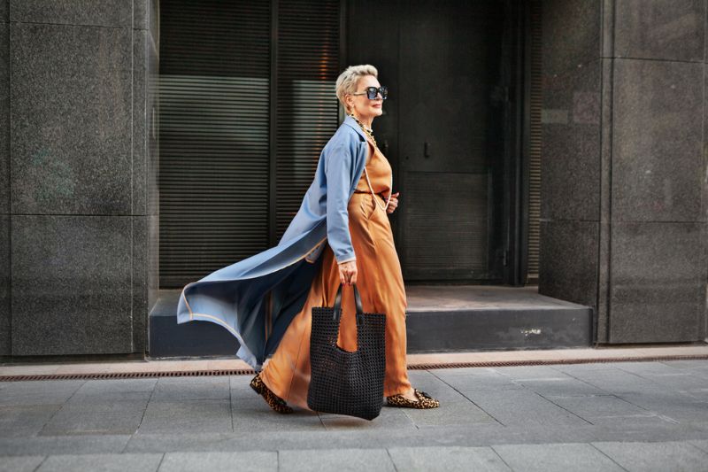Confident professional woman walking through the city in elegant attire, symbolising authenticity, confidence, and self-assured leadership.