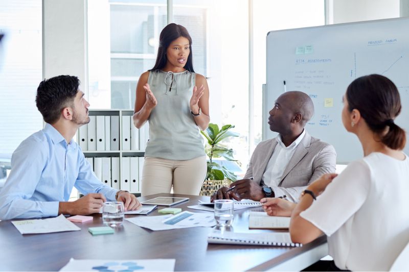 Female executive leading a diverse team meeting, exemplifying authentic leadership and collaboration.