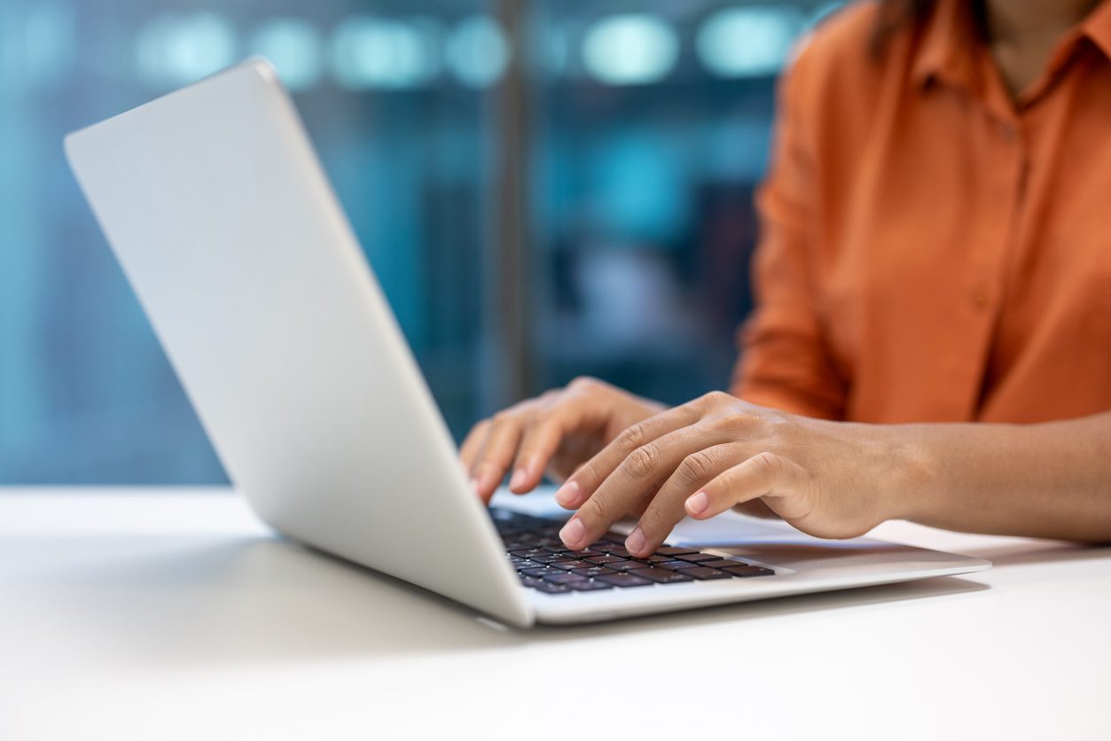 Close-up of a professional woman using a laptop to complete an online burnout barometer assessment.